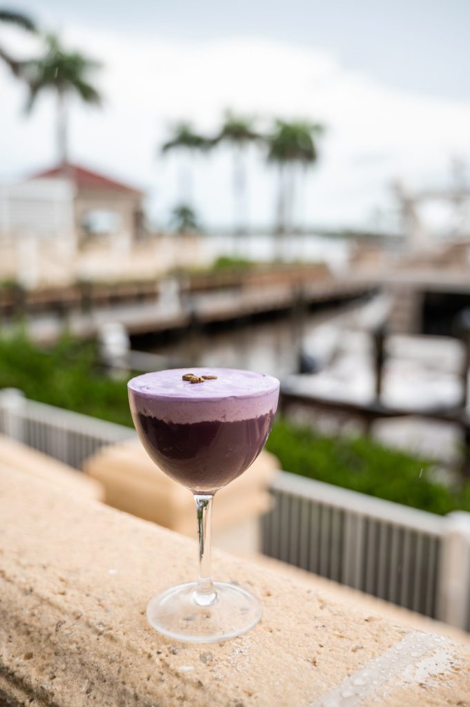 Purple cocktail overlooking the marina at Gather.