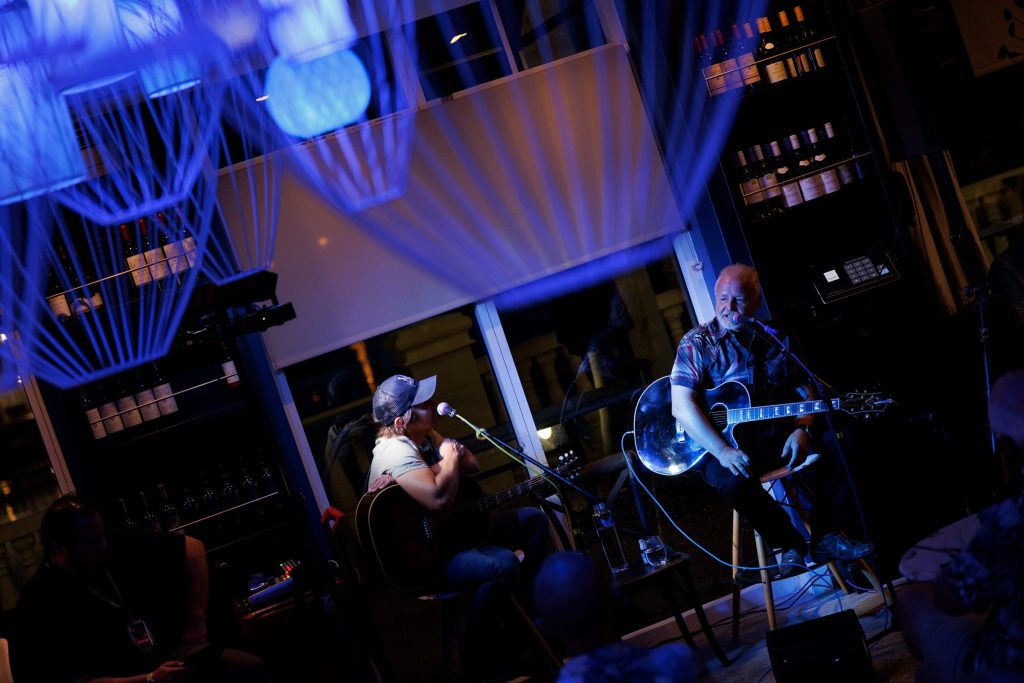 Two guitarists performing live inside Gather.